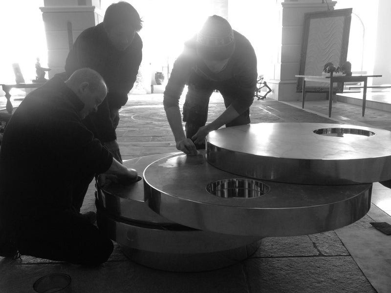 Artisans assembling circular marble furniture pieces in stone workshop