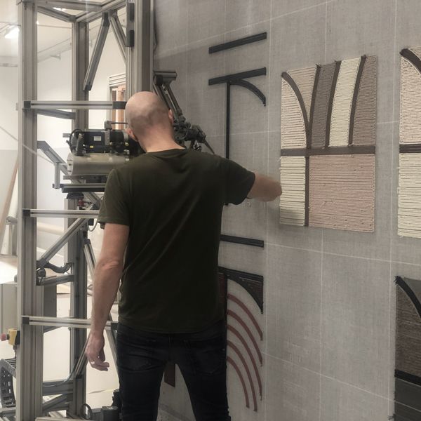 Textile artisan installing woven fabric artwork in contemporary interior
